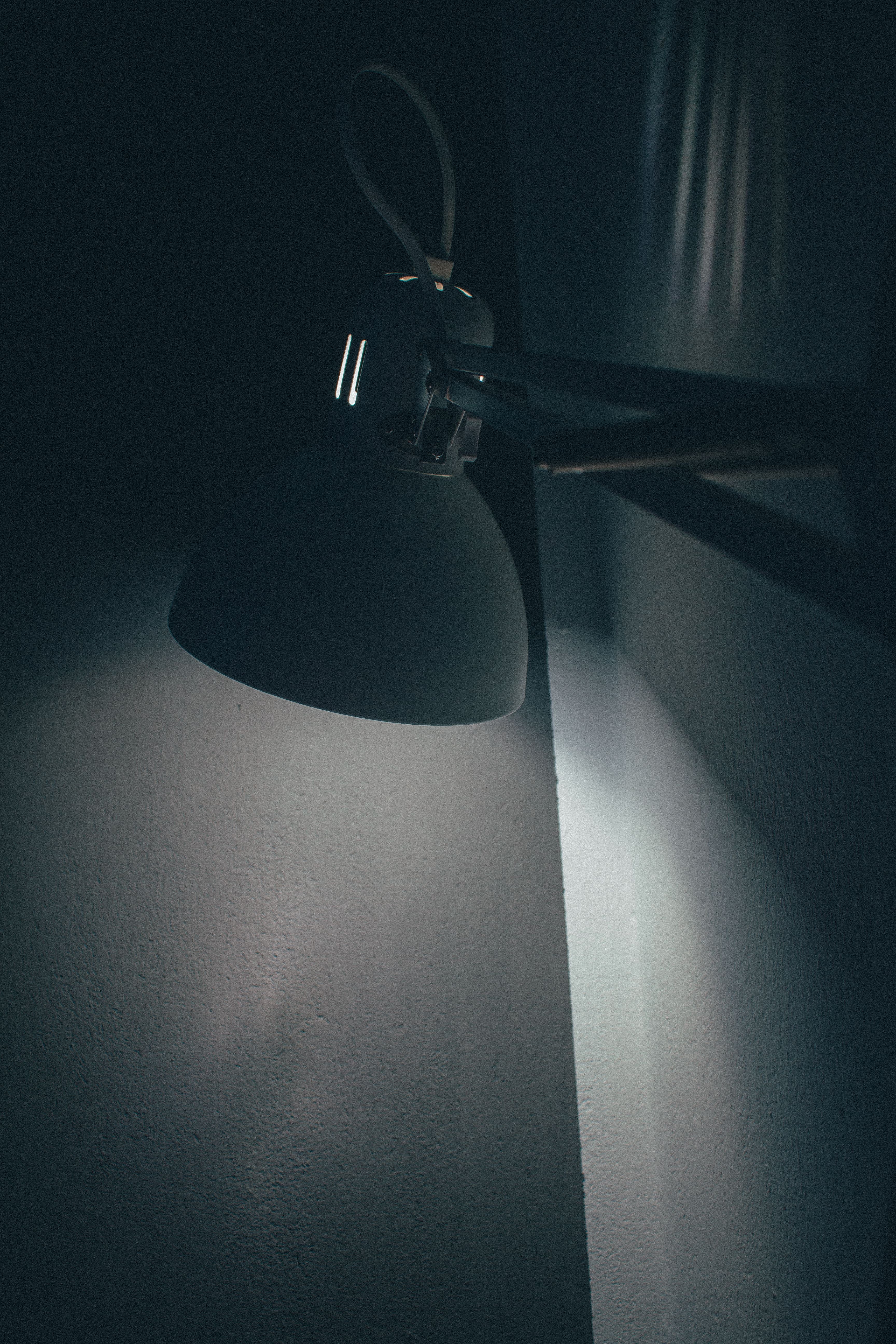 Warm sunset-toned lamp glow cast across a dark room wall
